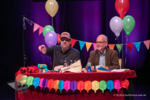 Ralf Kramp und Sebastian Carsten Henn auf der Bühne des Buchmesse Saar Festivals 2026, LIVE im Theater am Ring in Saarlouis