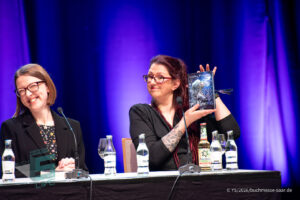 Laura Purcell auf der Bühne beim Buchmesse Saar Festival, LIVE in Saarlouis 2026, zusammen mit zwei Übersetzerinnen